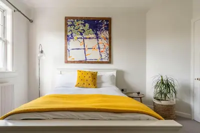 a bedroom with a bed with a yellow blanket at Peace in the City in Edinburgh