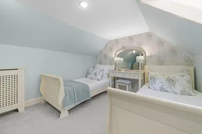 a attic bedroom with a bed and a mirror at The Strone Luss Premium Holiday Rental in Luss