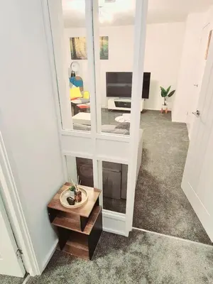 a hallway with a mirror and a living room at Cozy Flat in Glasgow City Centre in Glasgow