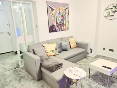 a living room with a couch and a table at Cozy Flat in Glasgow City Centre in Glasgow
