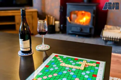 a bottle of wine and a chess board and a glass of wine at Historic 3 Bed Private Parking Nr Railway Station in Wemyss Bay