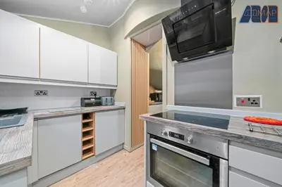 a kitchen with stainless steel appliances and white cabinets at Historic 3 Bed Private Parking Nr Railway Station in Wemyss Bay