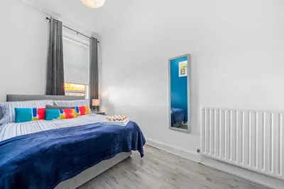 a bedroom with a bed with a blue blanket at Central Kirkintilloch 2 Bed App in Kirkintilloch