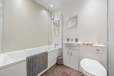 a white bathroom with a toilet and a sink at Central Kirkintilloch 2 Bed App in Kirkintilloch