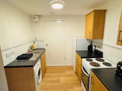 a kitchen with a sink and a stove top oven at Cosy flat in Glasgow in Maryhill