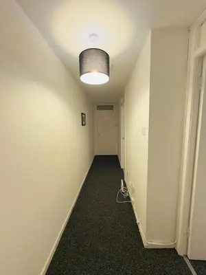 an empty hallway with a light on the ceiling at Cosy flat in Glasgow in Maryhill