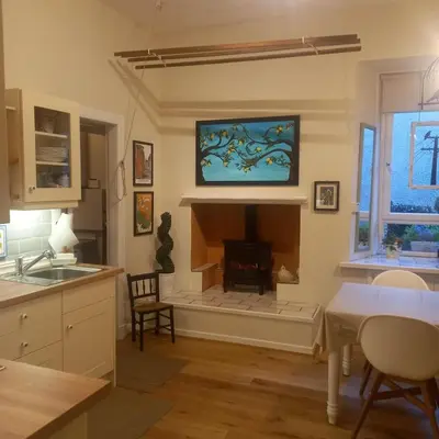 a kitchen with a fireplace with a tv on the wall at Carvetii - Abbey View, 1st Floor Flat, City Centre in Dunfermline