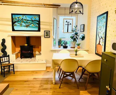 a dining room with a table and a fireplace at Carvetii - Abbey View, 1st Floor Flat, City Centre in Dunfermline