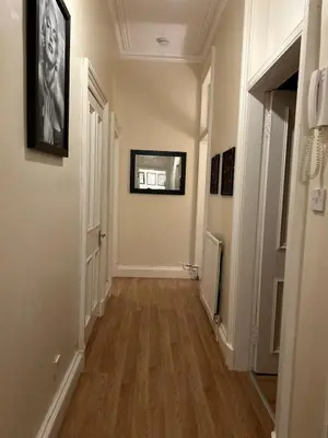 a hallway of a home with wooden floors and paintings at VS-Entire Flat-Central Scotland-Falkirk, Self-Check-in , Pet-friendly with Parking in Falkirk