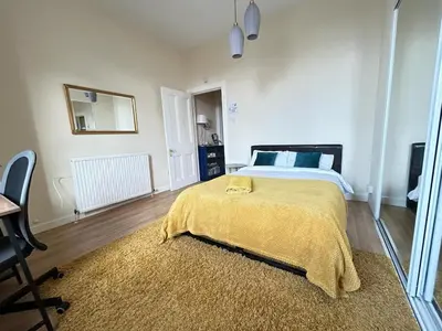 a bedroom with a bed with a yellow blanket on it at VS-Entire Flat-Central Scotland-Falkirk, Self-Check-in , Pet-friendly with Parking in Falkirk