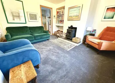 a living room with a green couch and chairs at Cosy Cottage with Woodburner by Crinan Canal Pets Welcome in Cairnbaan