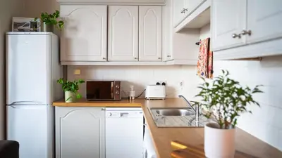a kitchen with white cabinets and a sink at 20min train to Edinburgh, The Coorie Inn in Inverkeithing