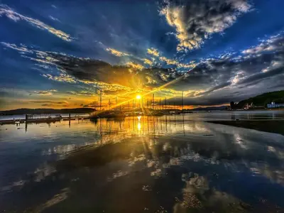 a sunset over a body of water with the sun setting at 17 Oban in Oban