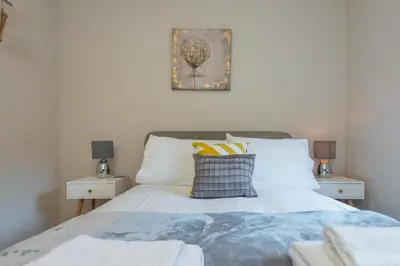 a bedroom with a white bed with two night stands at The Maltings in Edinburgh