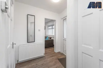 a hallway with white walls and a door with a mirror at Modern 3 Bed Home in Bathgate with Garden in Armadale