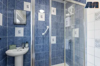 a blue tiled bathroom with a sink and a shower at Modern 3 Bed Home in Bathgate with Garden in Armadale