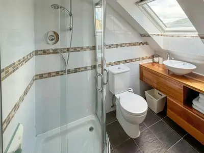 a bathroom with a shower and a toilet and a sink at Heatherdale in Dunoon