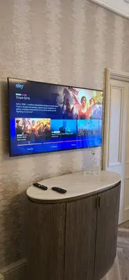 a flat screen tv hanging on a wall at 2 Bedroom Sofa bed in livingroom Castle View 1st floor sleeps 6 in Edinburgh