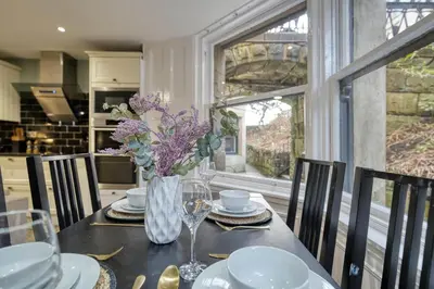 a dining room table with a vase of flowers on it at Stylish 3-Bedroom Apartment in Central Glasgow in Glasgow