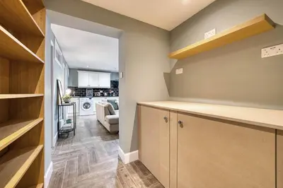 a kitchen with a counter and a living room at Stylish 3-Bedroom Apartment in Central Glasgow in Glasgow
