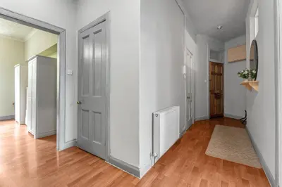 an empty hallway with white walls and wood floors at Central, Cozy 2BR-1BA-Haymarket - with Parking in Edinburgh