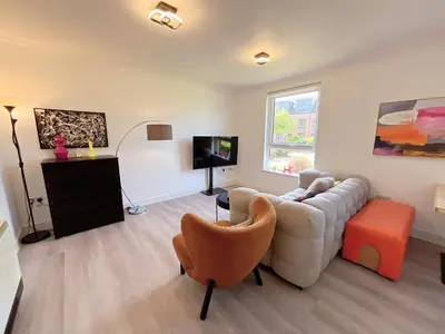 a living room with a couch and a tv at Quiet 2 bedrooms and 2 bathrooms with free parking in Edinburgh