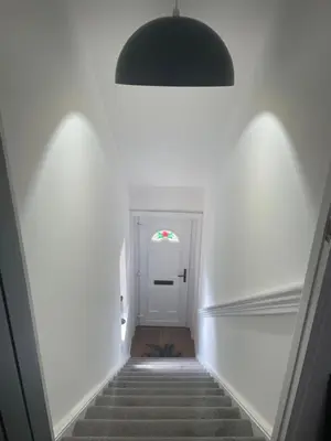 a stairway with a hallway with a white door at Spacious 3 bed flat- Free parking Edinburgh & Fife in Inverkeithing
