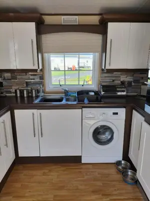 a kitchen with a sink and a washing machine at St Nicholas Number 5 in Turnberry