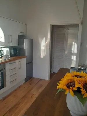 a kitchen with a vase filled with sunflowers on a table at Doune 3 Outlander Apartment 1st floor in Stirling