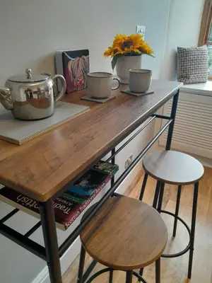 a kitchen counter with two stools and a table with two cups at Doune 3 Outlander Apartment 1st floor in Stirling