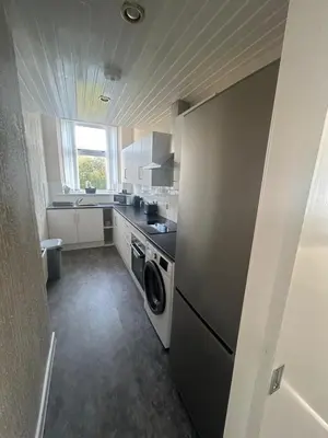 a kitchen with a washer and dryer in it at Hillhead Apartment in Coylton