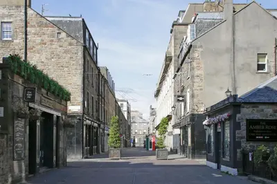 an empty street in an old town with buildings at Large Central 3 Bed 3 Bath Apartment - New Town in Edinburgh