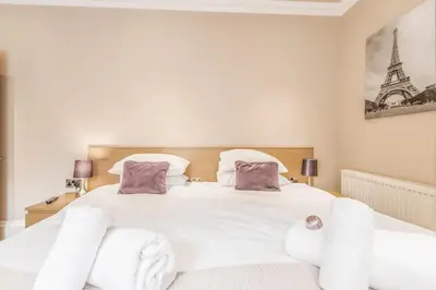 a bedroom with a white bed with white pillows at Large Central 3 Bed 3 Bath Apartment - New Town in Edinburgh