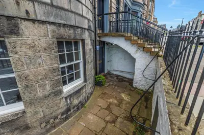 a brick building with a gate and a stairway at Large Central 3 Bed 3 Bath Apartment - New Town in Edinburgh