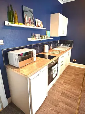 a kitchen with a microwave on top of a counter at Small Cosy Flat in Helensburgh