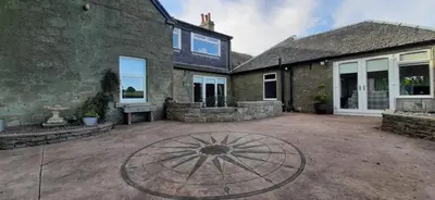 a patio in front of a house with a building at Marshill Farmhouse in Blackwood