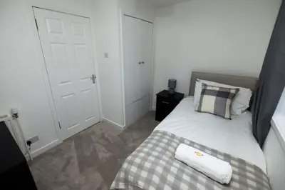 a bedroom with a bed and a white door at Pristine 3 bedroom house in East Kilbride