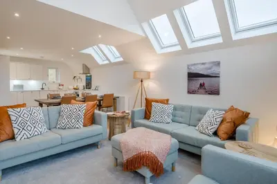 a living room with two blue couches and a kitchen at 3 Bed in Fearnan oc-s29984 in Chesthill