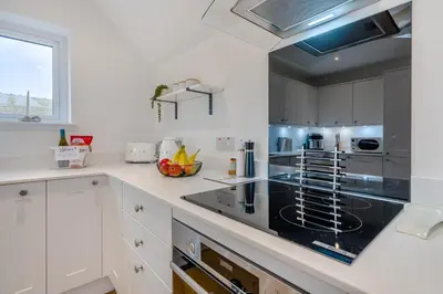 a kitchen with white cabinets and a black counter top at 3 Bed in Fearnan oc-s29984 in Chesthill