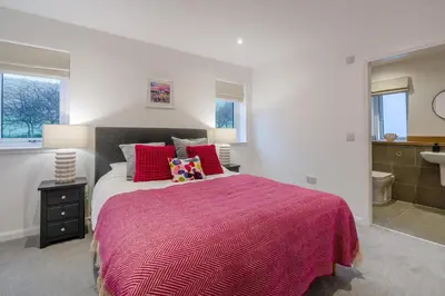 a bedroom with a large bed with red pillows at 3 Bed in Fearnan oc-s29984 in Chesthill