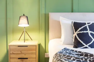 a lamp on a night stand next to a bed at The Annick Suite No2 - Donnini Apartments in Irvine