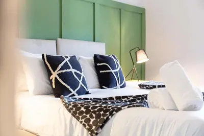 a bedroom with a white bed with blue pillows at The Annick Suite No2 - Donnini Apartments in Irvine