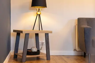 a table with a lamp on it next to a couch at The Annick Suite No2 - Donnini Apartments in Irvine