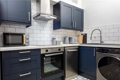 a kitchen with blue cabinets and a dishwasher at The Annick Suite No2 - Donnini Apartments in Irvine