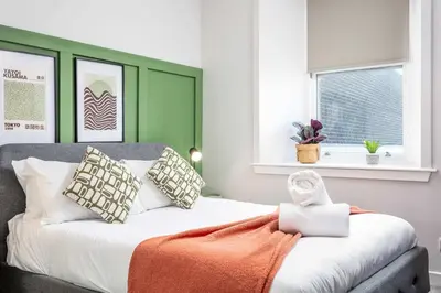a bedroom with a bed with an orange blanket on it at The Annick Suite No2 - Donnini Apartments in Irvine