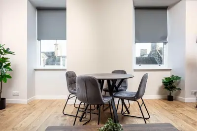 a dining room with a table and chairs and windows at The Annick Suite No2 - Donnini Apartments in Irvine