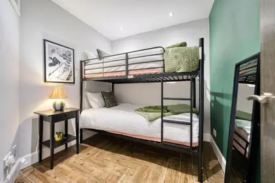 a bedroom with two bunk beds and a table at Spacious 4 Bedroom Apt Near West End Glasgow in Glasgow
