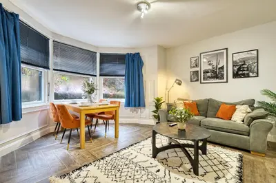 a living room with a couch and a table at Spacious 4 Bedroom Apt Near West End Glasgow in Glasgow