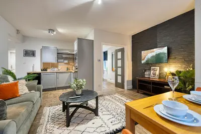 a living room with a couch and a table at Spacious 4 Bedroom Apt Near West End Glasgow in Glasgow