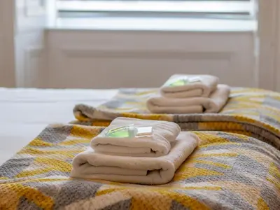 three folded towels sitting on top of a bed at City Haven Main Door & Parking - Pass the Keys in Glasgow